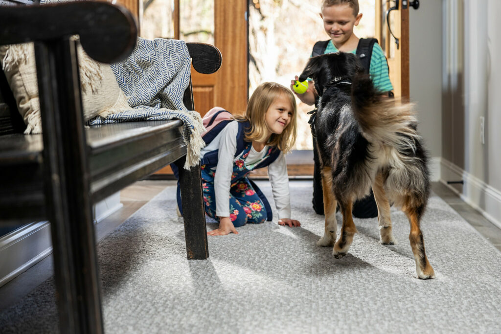 Kids playing with dog on carpet floors | Signature Flooring, Inc