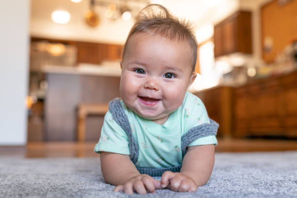 Baby lying on carpet floor | Signature Flooring, Inc